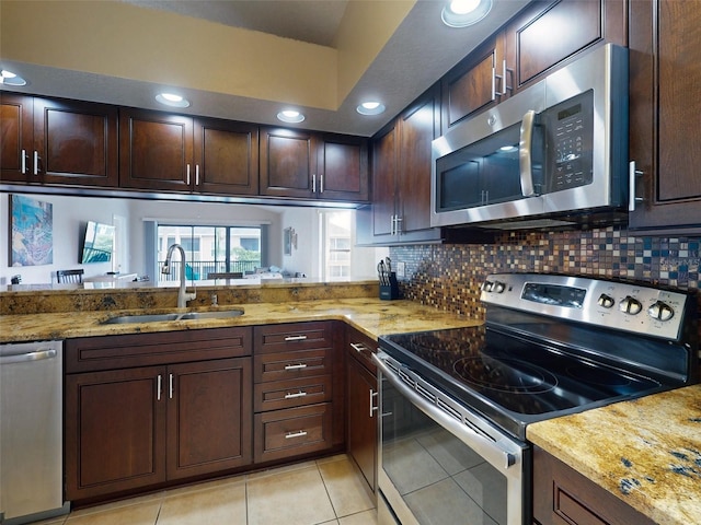 kitchen featuring stainless steel appliances, tasteful backsplash, sink, and light stone counters