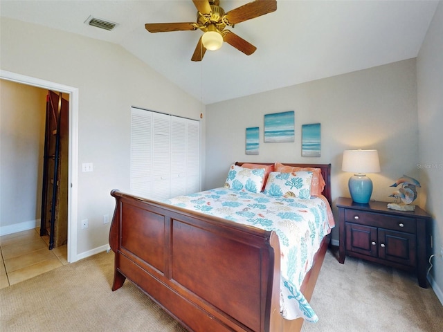 bedroom featuring ceiling fan, a closet, lofted ceiling, and light carpet