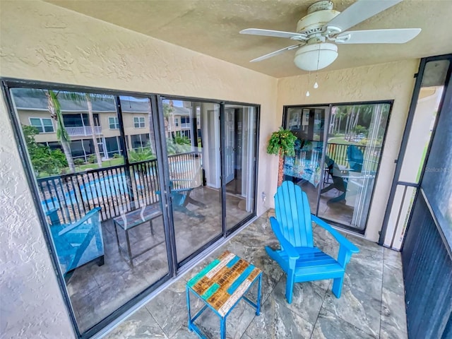 sunroom featuring ceiling fan