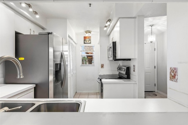 kitchen featuring light tile patterned floors, stainless steel appliances, and white cabinets