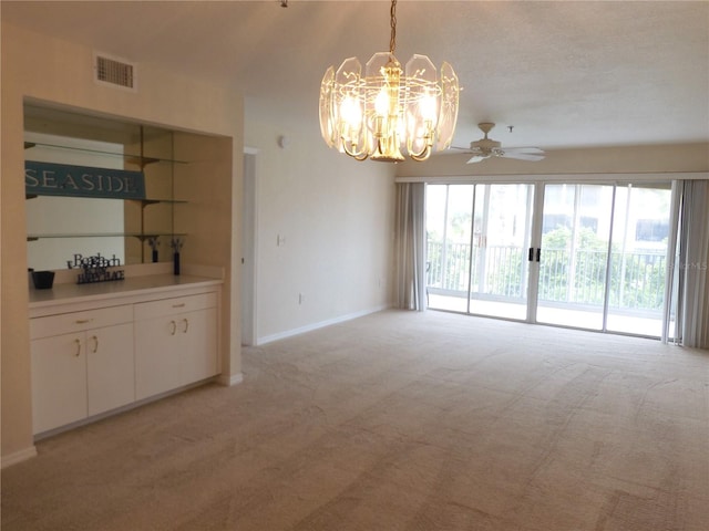 interior space featuring ceiling fan with notable chandelier, light colored carpet, and a textured ceiling