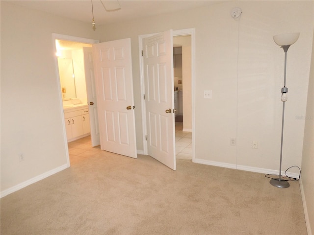 unfurnished bedroom featuring ensuite bath and light carpet