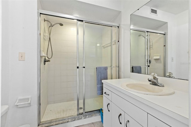 bathroom featuring vanity, toilet, tile patterned flooring, and a shower with door