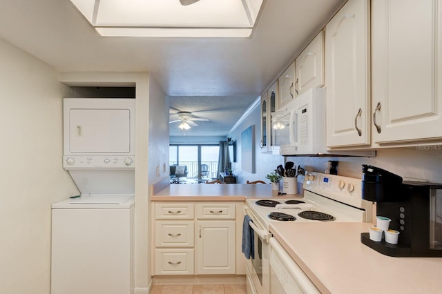 kitchen featuring ceiling fan, stacked washer / dryer, light tile patterned flooring, and white appliances