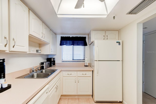 kitchen featuring ceiling fan, white cabinetry, sink, light tile patterned flooring, and white appliances