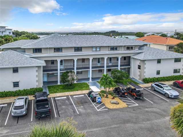 view of property with a residential view and uncovered parking