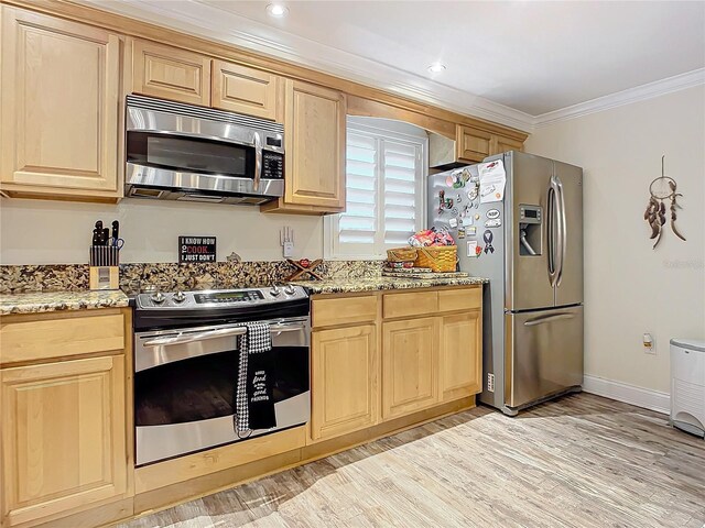 kitchen with light brown cabinets, stainless steel appliances, and light wood-type flooring