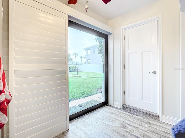 entryway with baseboards, ceiling fan, and light wood finished floors