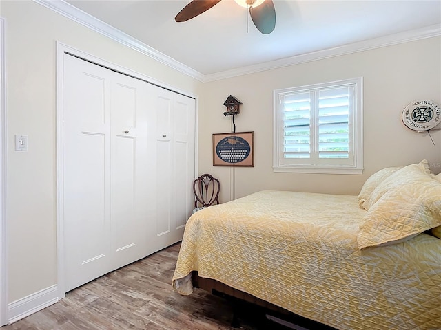 bedroom with ceiling fan, a closet, crown molding, and wood finished floors