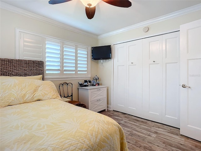 bedroom with a ceiling fan, a closet, ornamental molding, and wood finished floors