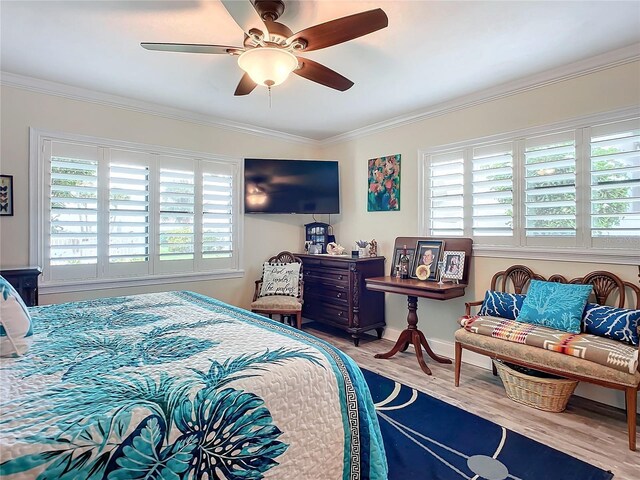 bedroom featuring multiple windows, ceiling fan, wood-type flooring, and ornamental molding