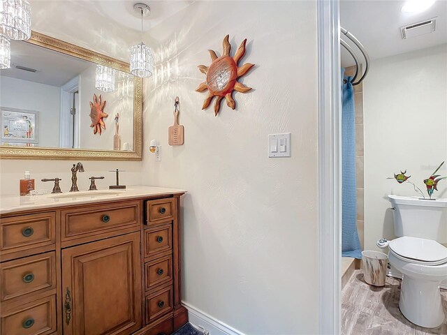 bathroom with wood-type flooring, vanity, and toilet