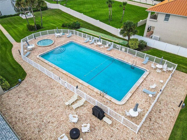 pool featuring a patio, fence, and a hot tub