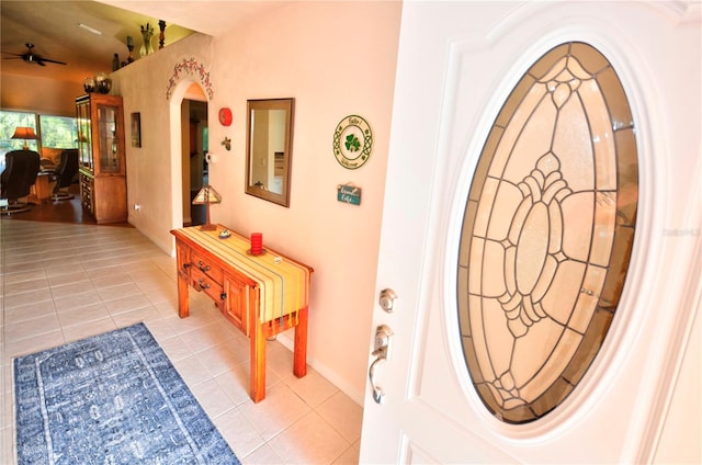 foyer entrance with ceiling fan and light tile patterned flooring