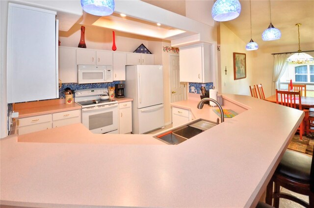 kitchen with a kitchen bar, tasteful backsplash, white appliances, and white cabinets