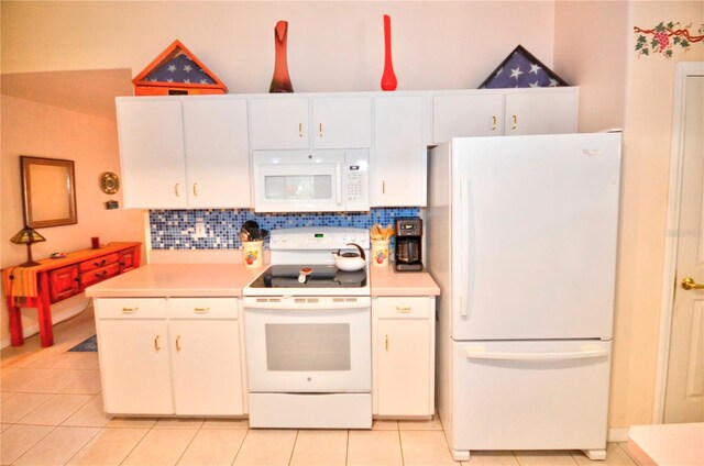 kitchen with white appliances, white cabinets, light tile patterned floors, and tasteful backsplash