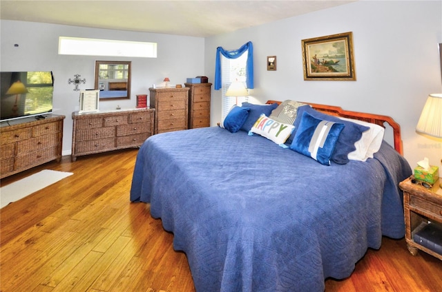 bedroom with multiple windows and dark hardwood / wood-style flooring