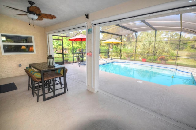 view of swimming pool featuring ceiling fan, glass enclosure, and a patio area