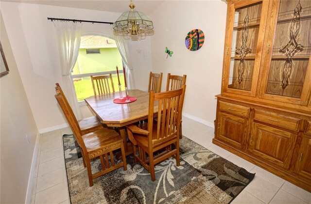 dining room with light tile patterned flooring and a notable chandelier