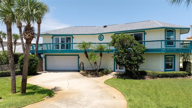 raised beach house with a garage and a front lawn