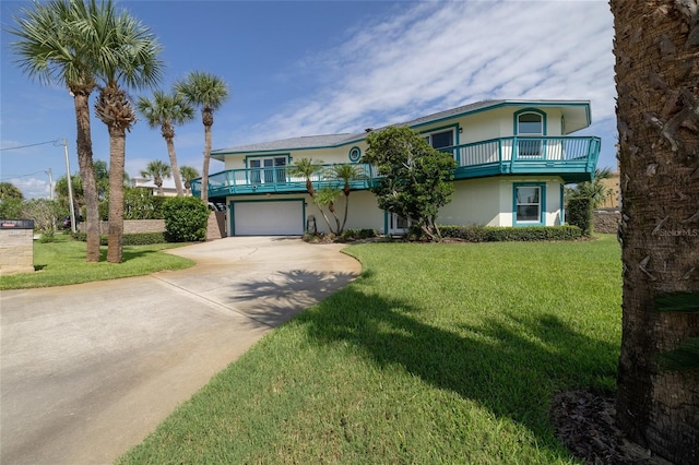 view of front of home with a front yard, a balcony, and a garage