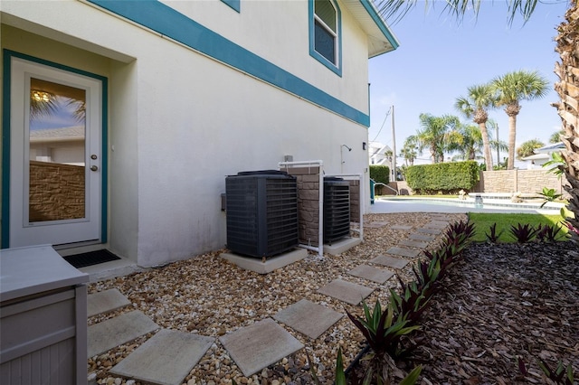 exterior space featuring central AC and fence