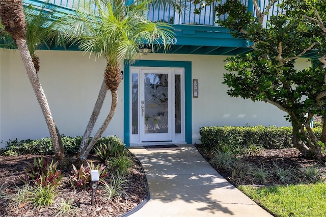 doorway to property featuring stucco siding