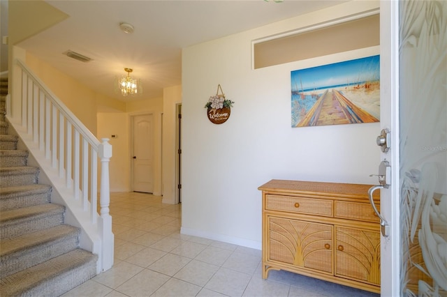 entryway with light tile patterned floors, visible vents, stairway, a chandelier, and baseboards