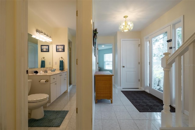 bathroom featuring toilet, an inviting chandelier, tile patterned flooring, and vanity