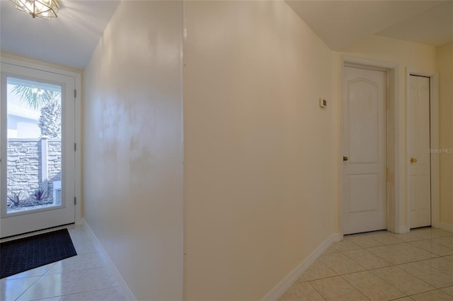 interior space featuring light tile patterned flooring and baseboards