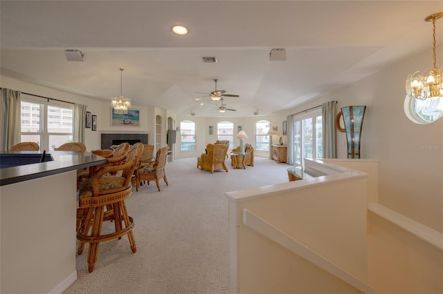 interior space with a fireplace, recessed lighting, visible vents, light carpet, and vaulted ceiling