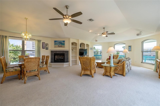 living area with light carpet, visible vents, a fireplace with raised hearth, and lofted ceiling