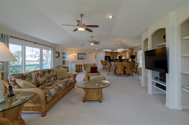 carpeted living room featuring lofted ceiling, built in shelves, a ceiling fan, and baseboards