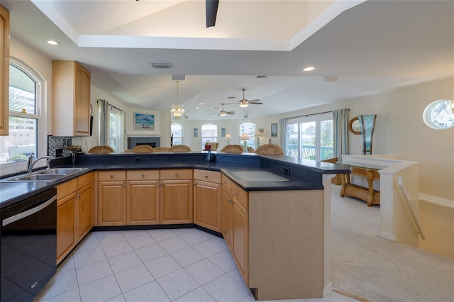 kitchen featuring dark countertops, vaulted ceiling, dishwasher, and a sink