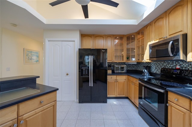 kitchen with decorative backsplash, black appliances, dark countertops, a raised ceiling, and glass insert cabinets