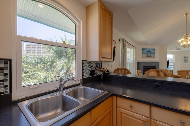 kitchen with dark countertops, open floor plan, a fireplace, and a sink