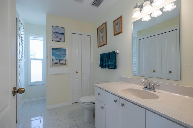 bathroom with visible vents, toilet, tile patterned floors, vanity, and a closet