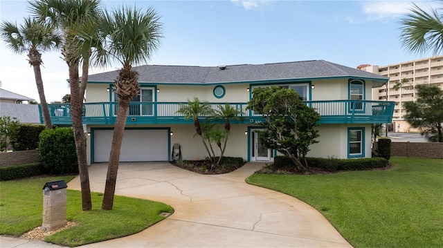 view of front of property with a balcony, a front lawn, and a garage