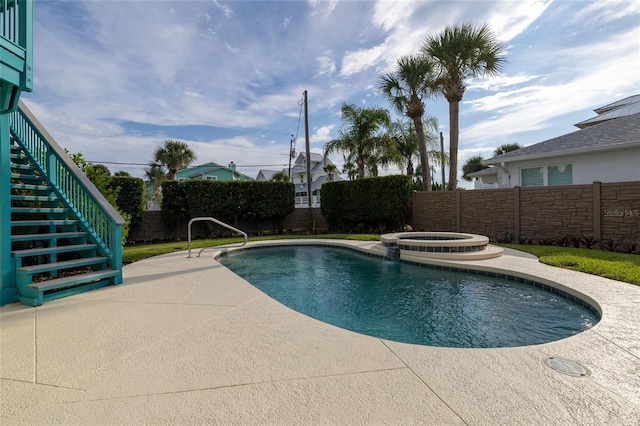 view of swimming pool with a pool with connected hot tub, fence, a patio, and stairs