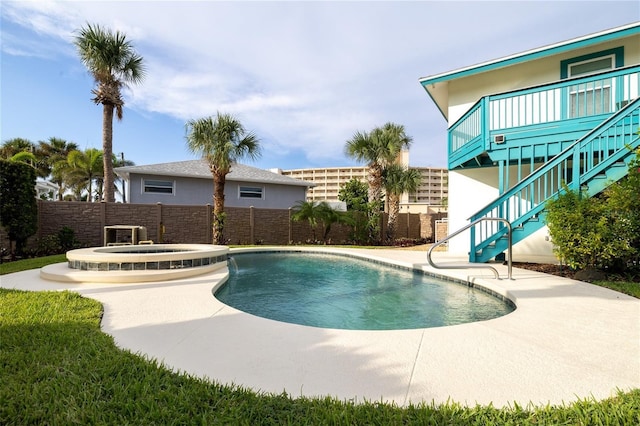 view of pool featuring stairs, a patio area, fence, and a pool with connected hot tub