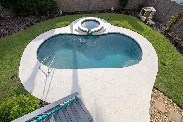 view of pool featuring a yard, fence, and an in ground hot tub