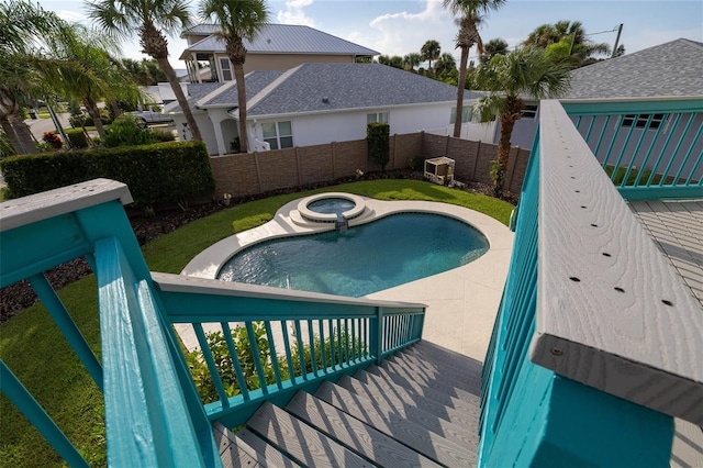 view of swimming pool featuring a fenced backyard and a pool with connected hot tub