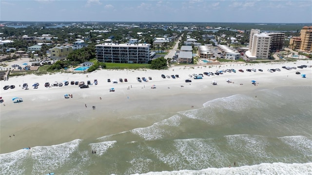 drone / aerial view featuring a water view, a view of city, and a view of the beach