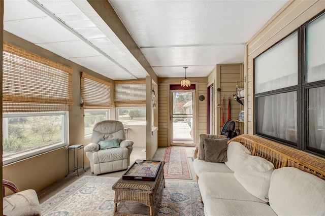 living room with a wealth of natural light and wooden walls