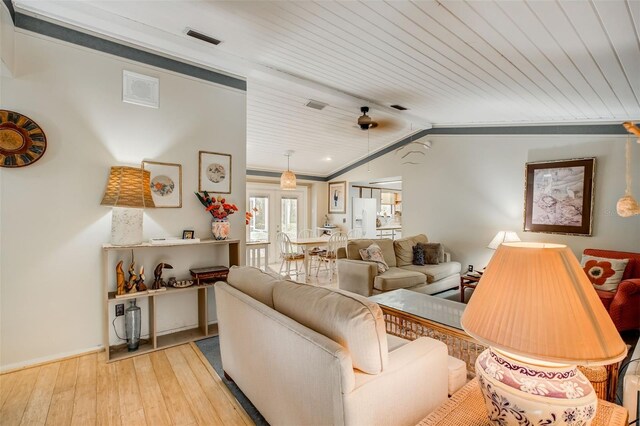 living room featuring vaulted ceiling, light hardwood / wood-style floors, wooden ceiling, and crown molding