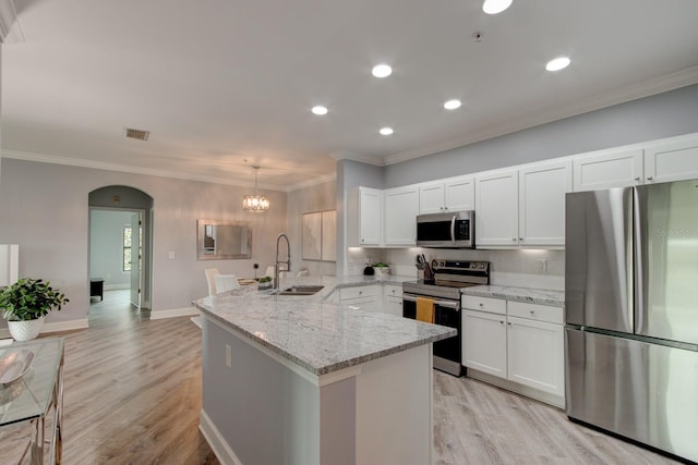 kitchen with backsplash, appliances with stainless steel finishes, light stone counters, light hardwood / wood-style floors, and hanging light fixtures