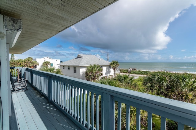 balcony with a water view and a view of the beach