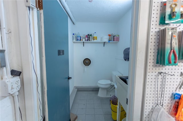 bathroom with vanity, tile patterned flooring, toilet, and a textured ceiling