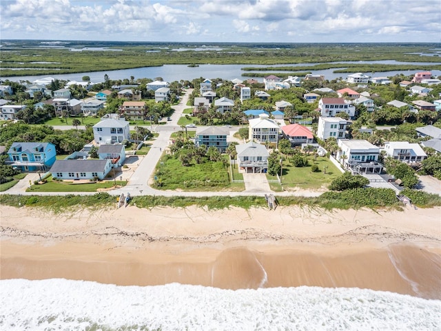 drone / aerial view featuring a beach view and a water view