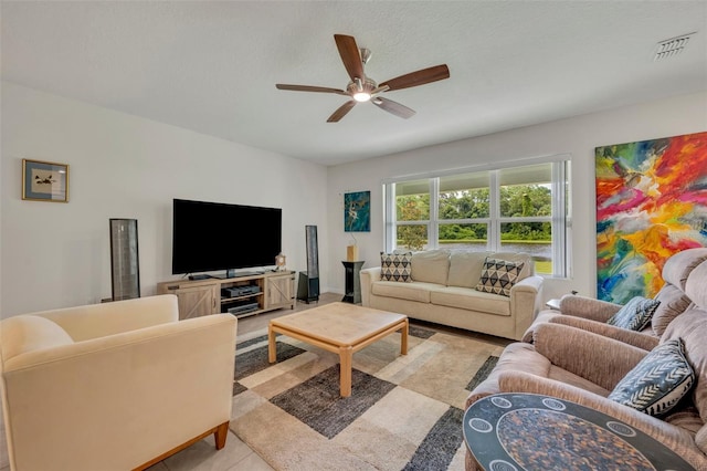 living room featuring a ceiling fan, visible vents, a textured ceiling, and light tile patterned floors